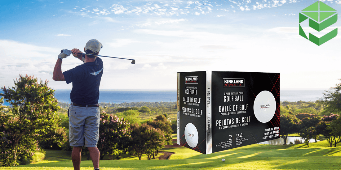 A golfer swings on a scenic golf course with an ocean view, while a box of Kirkland Signature Golf Balls is prominently displayed in the foreground. The packaging highlights the 3-piece urethane cover and performance features.